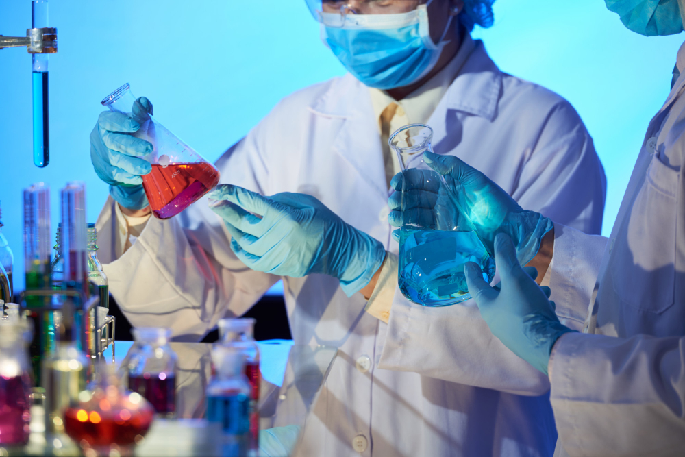 Laboratory technician holding colored chemical samples in vials